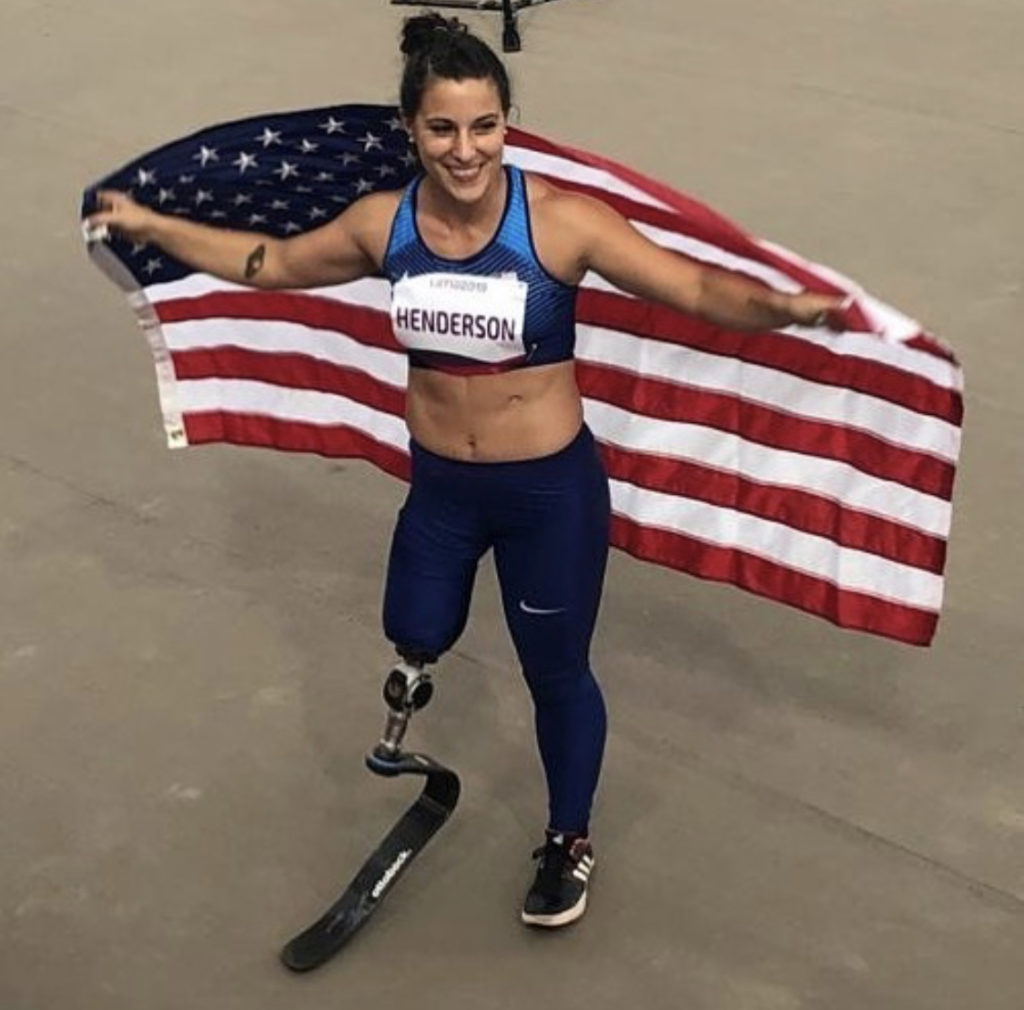 lacey henderson stands holding a us flag behind her