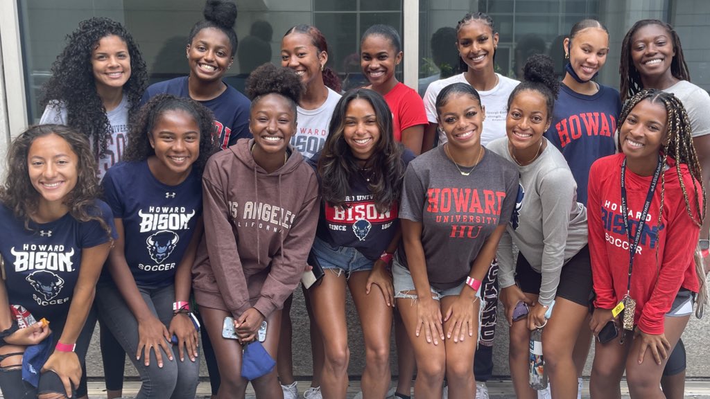 Members of the Howard University women's soccer team post together outside a building.