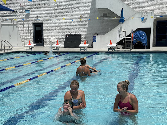 Tulane swim and dive student-athletes standing in a pool helping Special Olympics athletes.