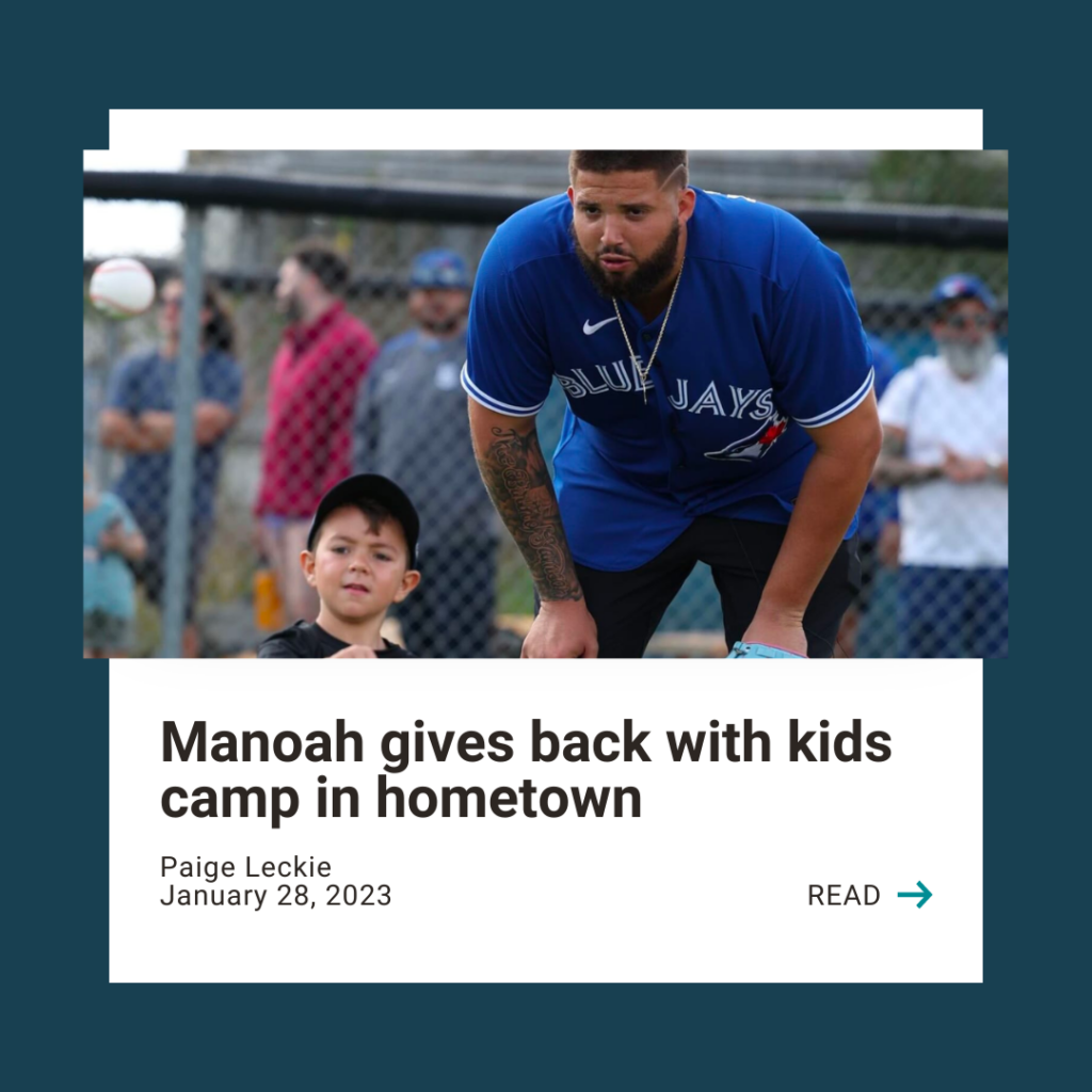Photo of Blue Jay's Manoah with a young child on a baseball field. Text reads: "Manoah gives back with kids camp in hometown" with a call to action to click the image to read the full article.