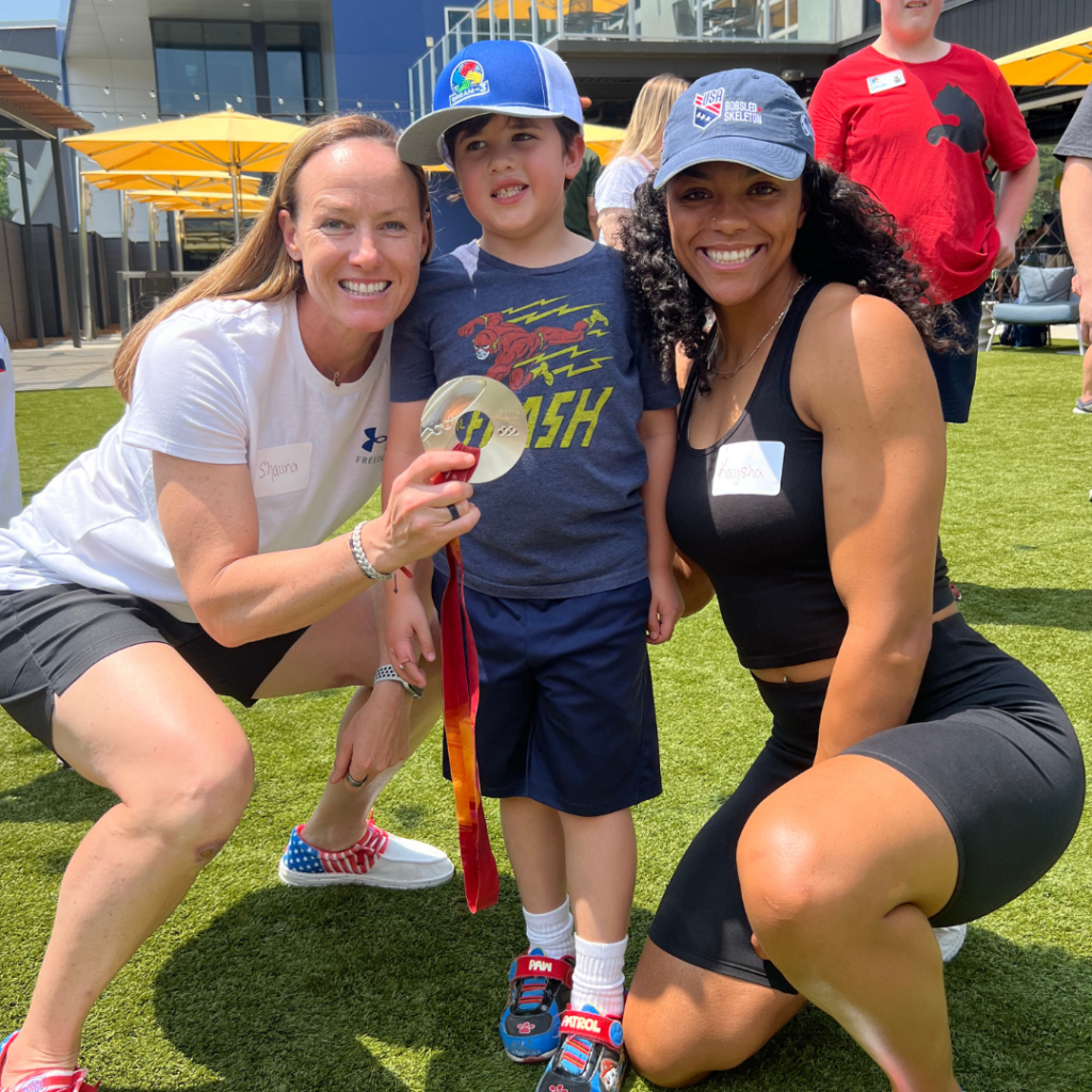 Two members of USABS smile with a member of Take on Sports at the Dream on 3 Topgolf event.