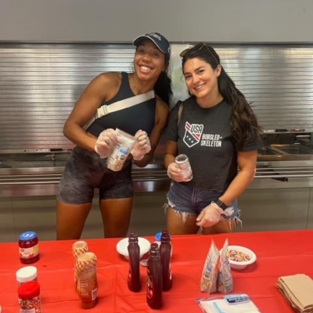 Two members of USABS smile while setting up an ice cream station at the Salvation Army Center of Hope Shelter event.