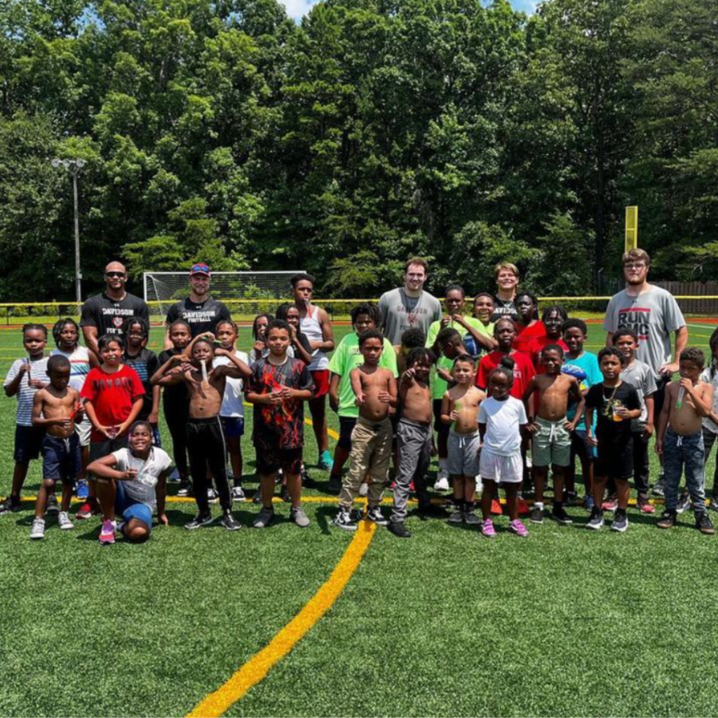 Members of the Davison football team pose for a photo with participants of the football clinic.