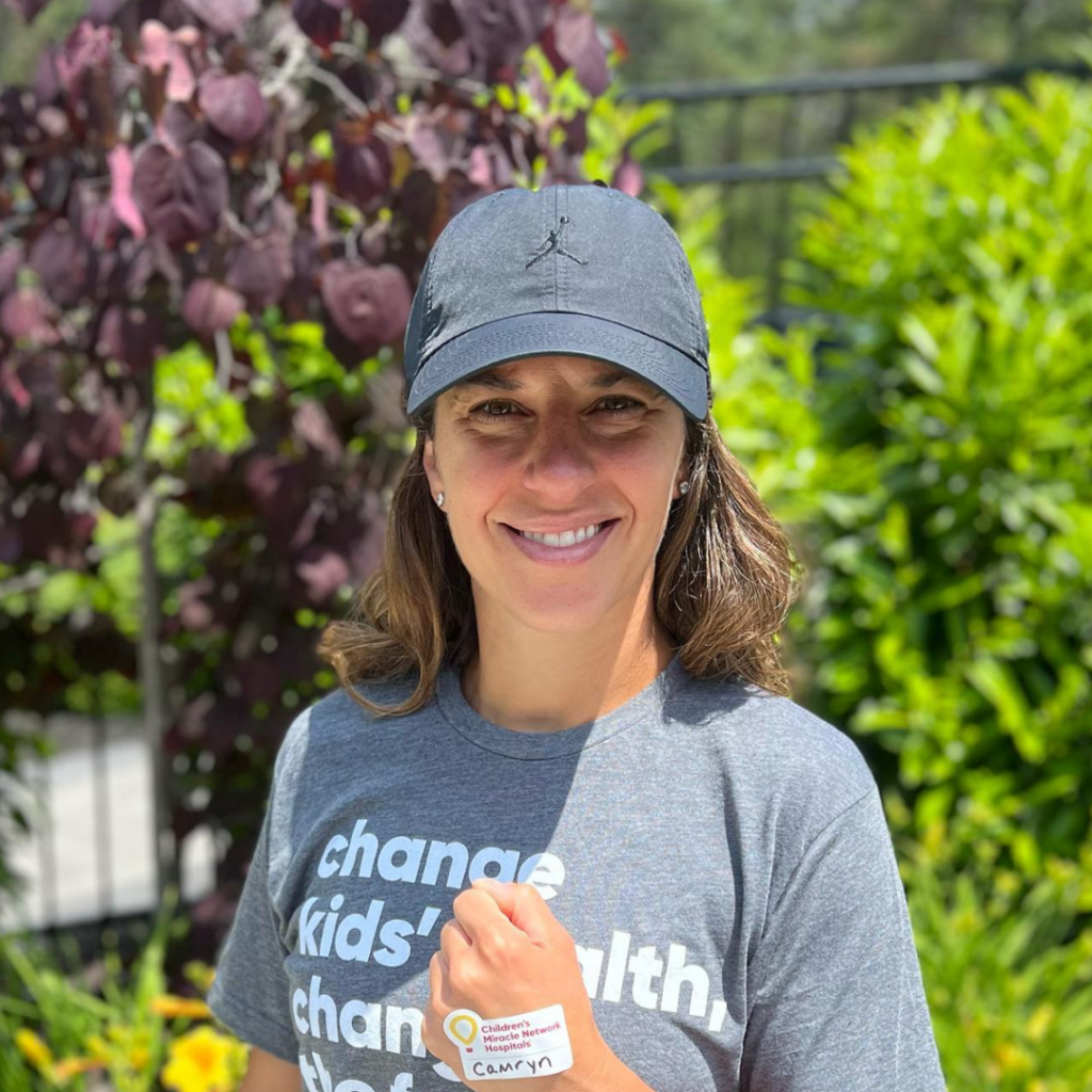 Photo of Carli Lloyd smiling with a Children's Miracle Network sticker on her hand.