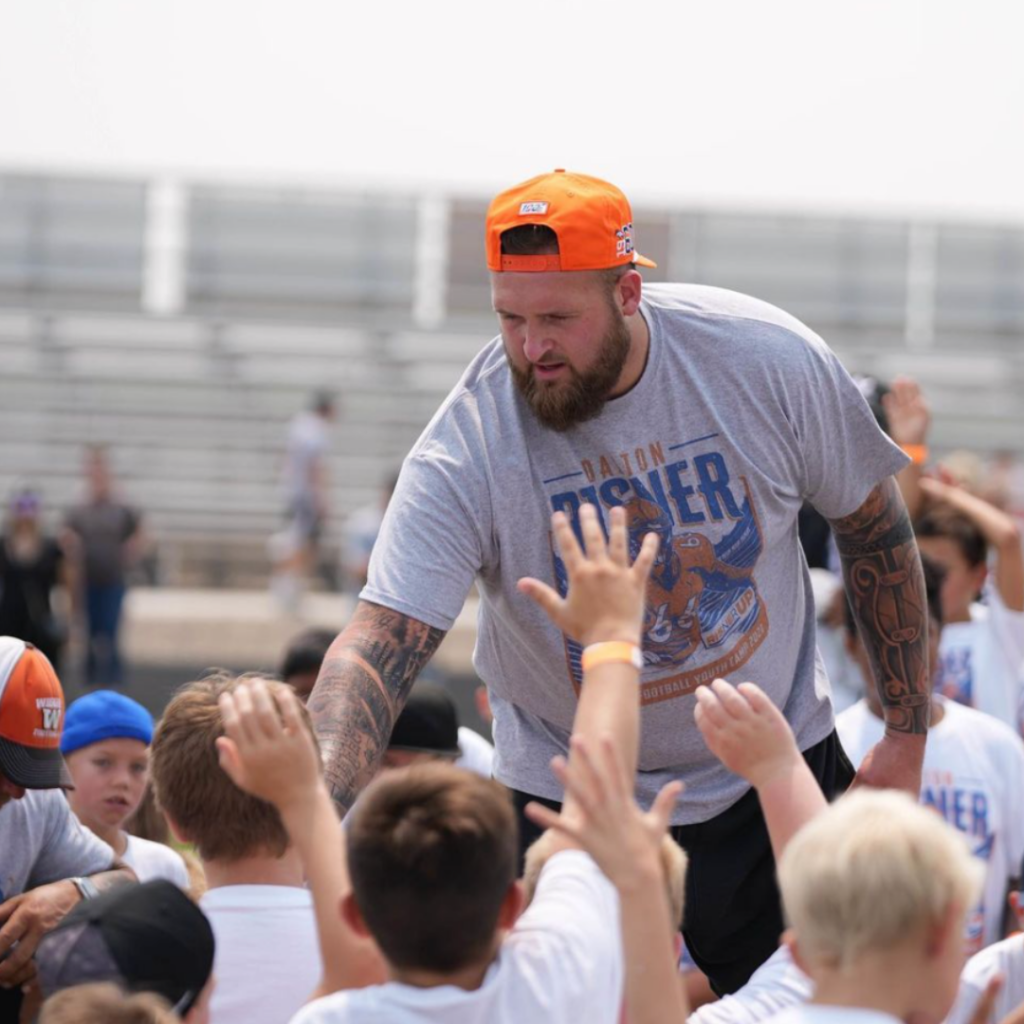 Dalton tells participants of the RisnerUp football camp to put their hands in for a team chant before getting started.