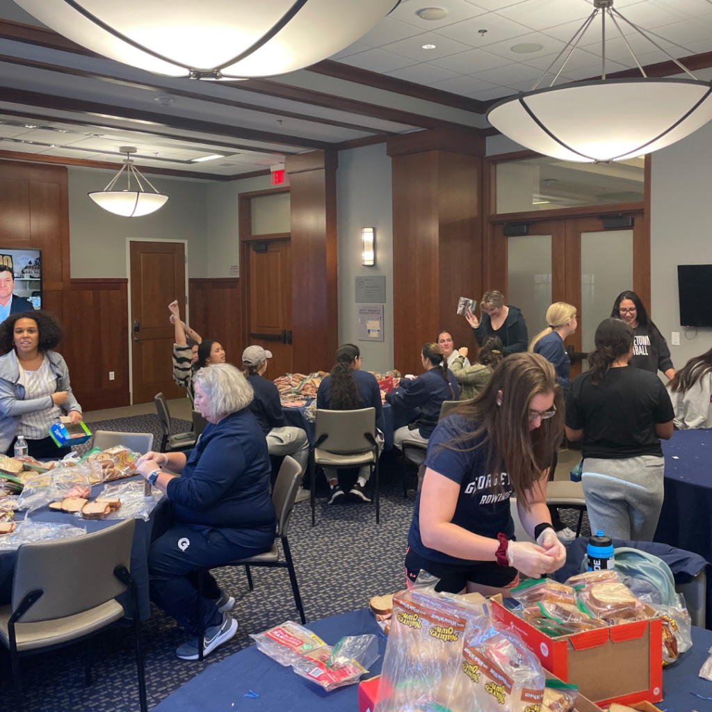 Georgetown student-athletes work together to package sandwiches made.