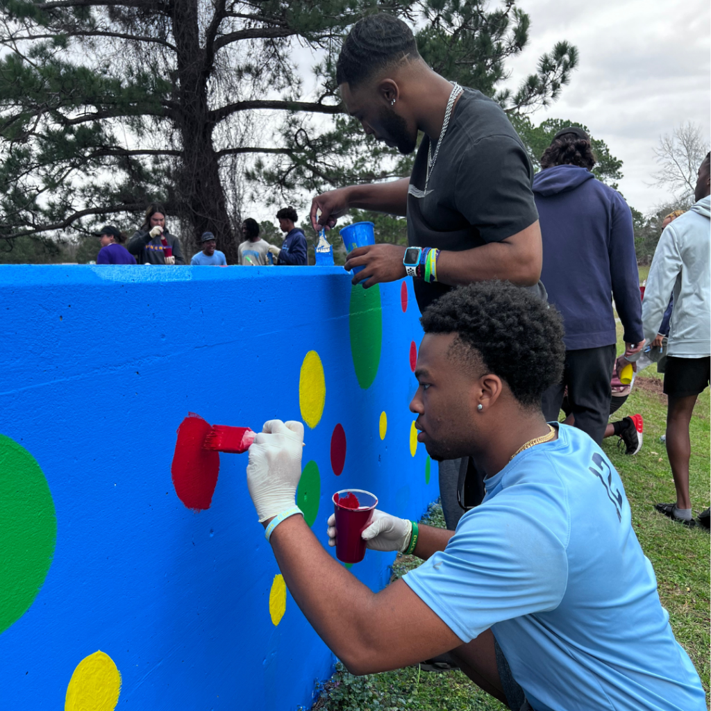 Southern University student-athletes paint at the Scottlandville Beautification Project, an MLK Day volunteer opportunity.