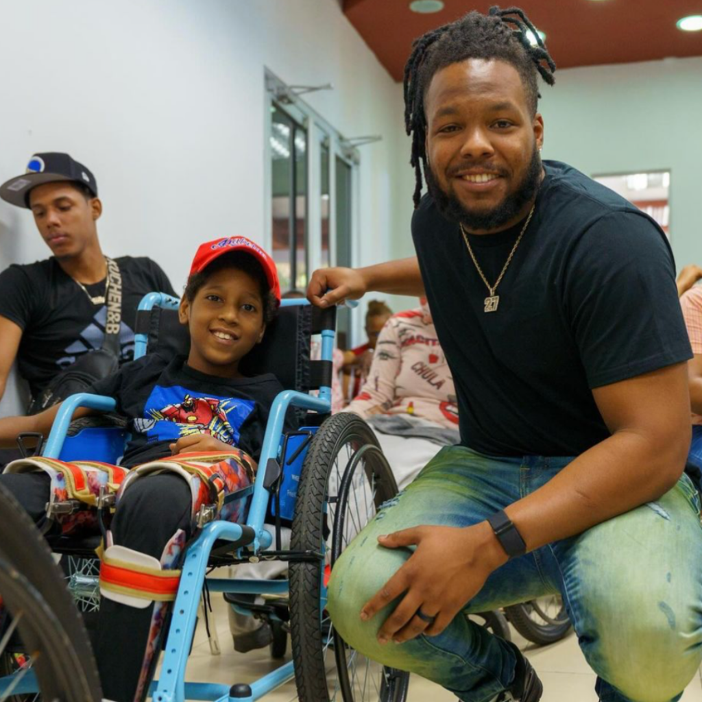 Vladimir Guerrero Jr. smiles next to a differently-abled child.