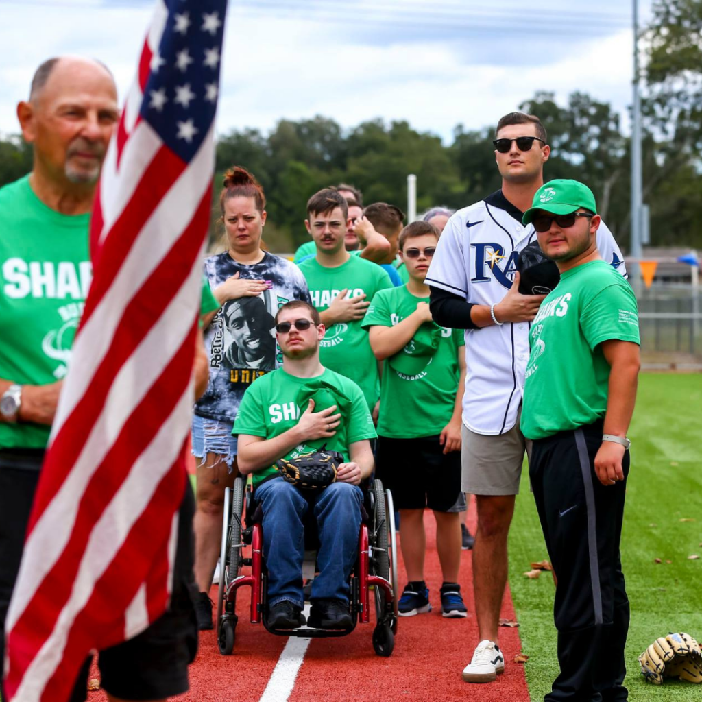 Shane McClanahan stands with his friends at Buddy Baseball for the National Anthem.