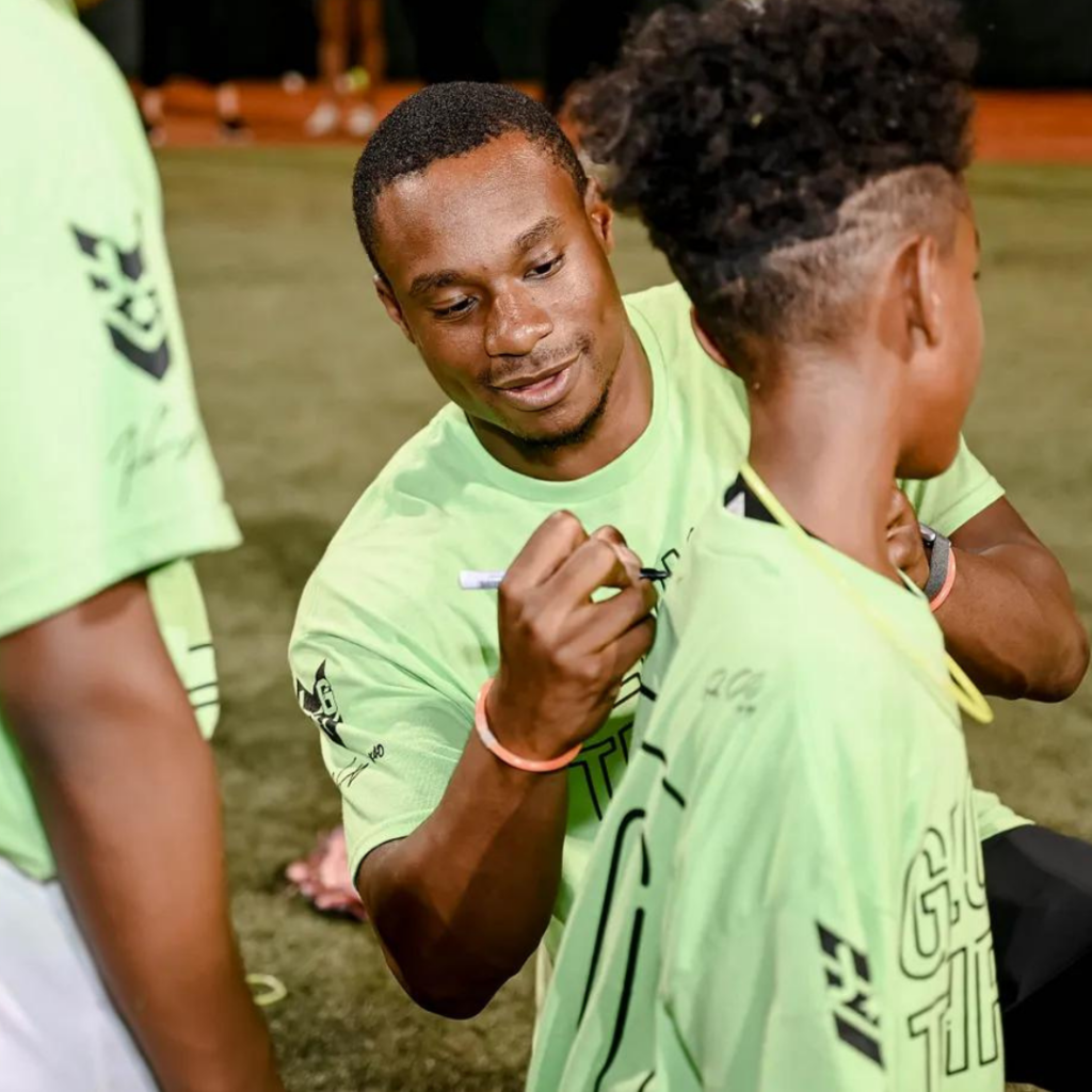 Josiah Gray signs a tshirt during his Glow & Throw with Jojo event.