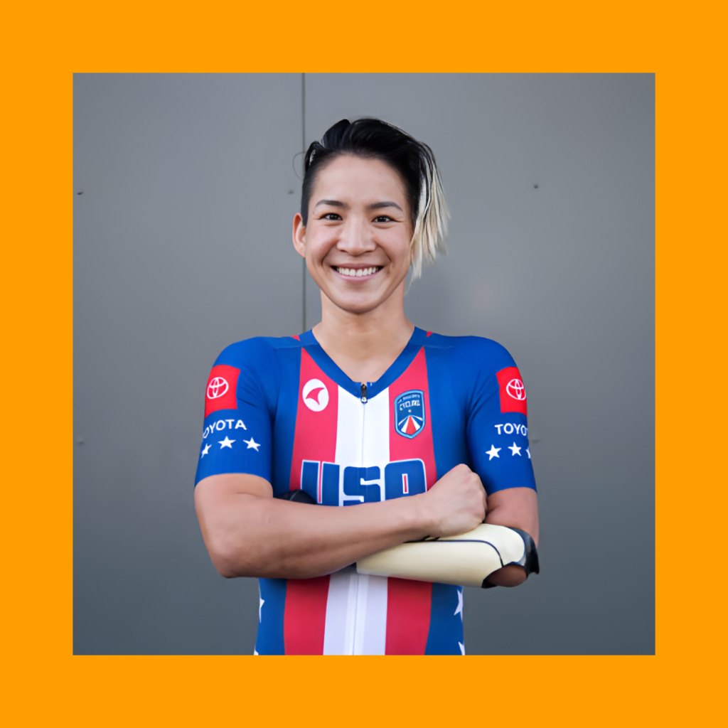 Photo of Katie Walter on a yellow background. Katie is wearing a biking shirt with her arms folded in front and she is smiling.