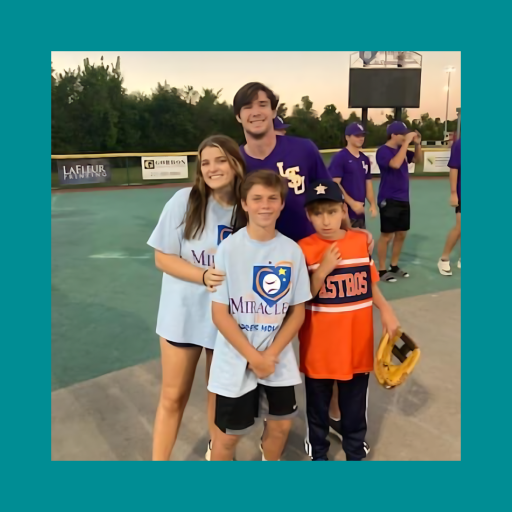 LSU student-athletes pose with Miracle League participants (two children) on a softball field in Baton Rouge.