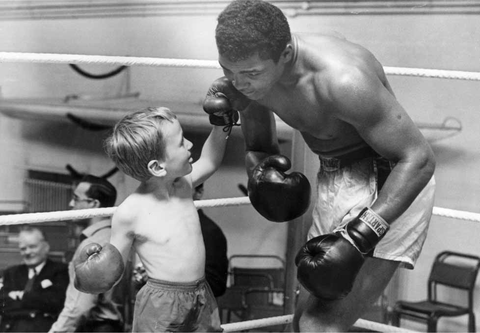 Child and adult playfully boxing together